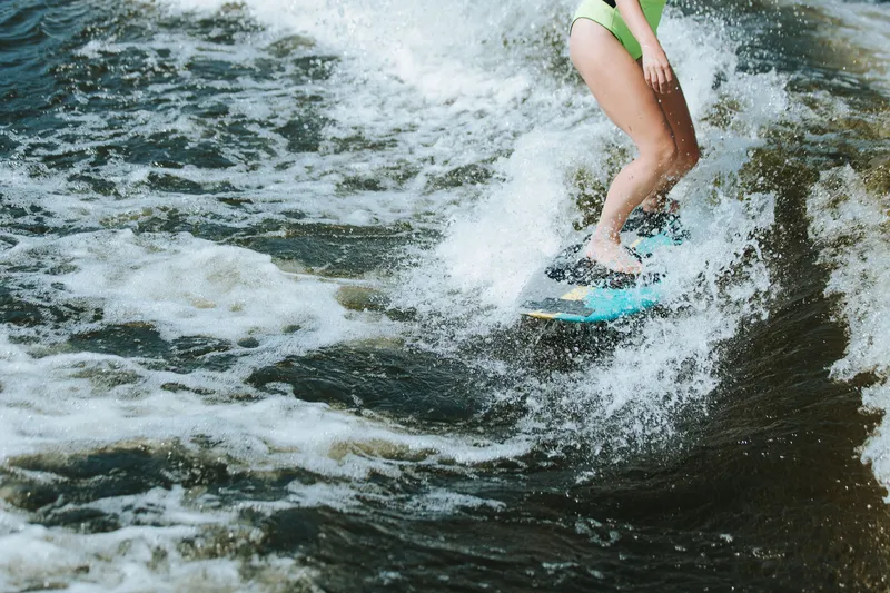 Surfer balancing low over a moving board