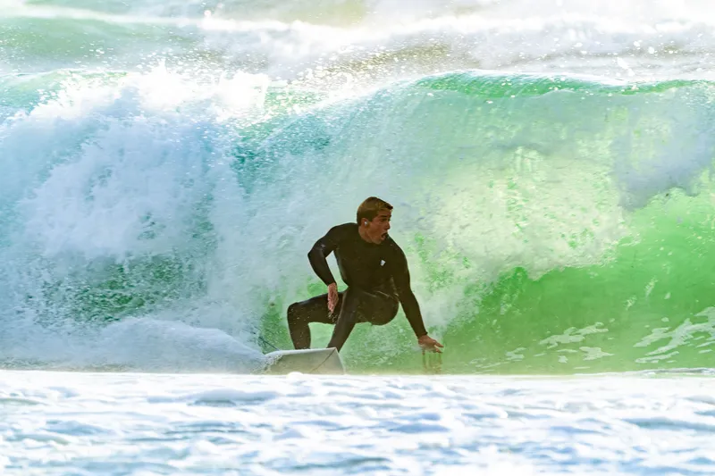 Surfer driving through a bright wave barrel